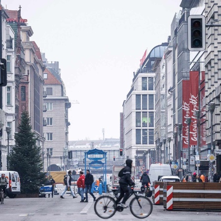 Berlin: Passanten und Fahrradfahrer passieren die Fahrbahn der Friedrichstraße