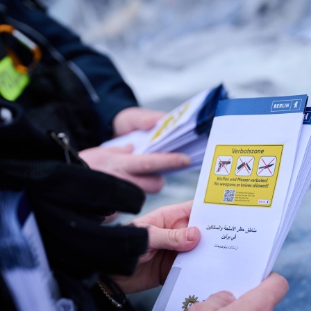 Polizeibeamtinnen und Beamten verteilen Flyer zur Messervebotszone-