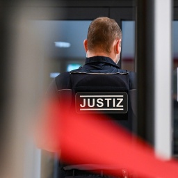 Ein Justizmitarbeiter steht hinter einer Sicherheitsschleuse zum Hochsicherheitssaal im Justizzentrum in Halle/Saale.