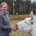 Iris Haver Rassfeld füttert einen Esel.
