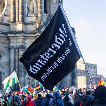 Demonstration in Dresden: Tausende Menschen demonstrieren auf dem Schlossplatz in Dresden und ziehen dann durch die Innenstadt. Dabei sind Fahnen des einstigen Königreiches Sachsen, die häufig von Anhängern der rechtsextremen Kleinstpartei Freie Sachsen mitgeführt werden, zu sehen. 