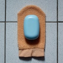 symbolbild: Ein Stück Seife liegt auf einem Peeling-Waschlappen