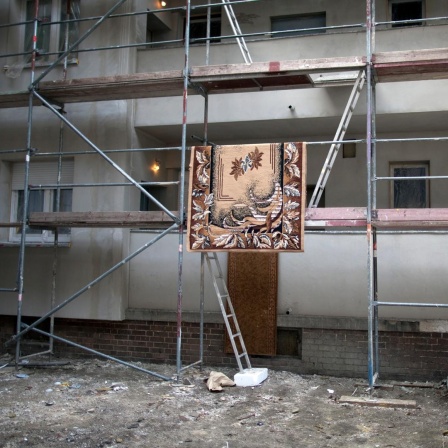 Ein Teppich hängt zum Trocknen auf einem Baustellengerüst in der Harzer Straße 65 in Berlin Neukölln. In dem Mehrfamilienhaus leben rund 400 Roma aus Rumänien. 