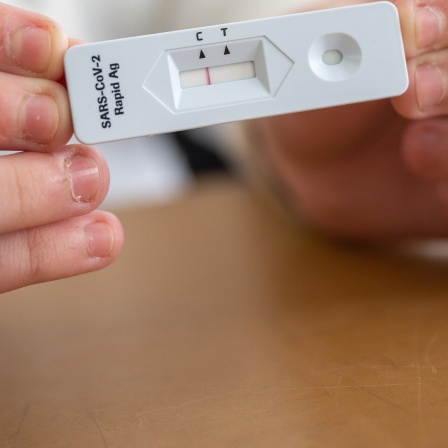 Ein Schülerin zeigt in einer Klasse ihren negativen Corona-Schnelltest.