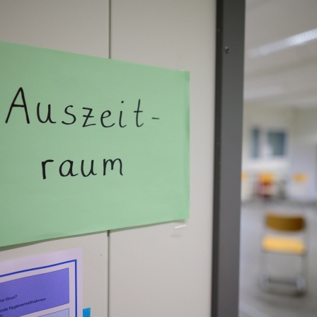 Auf einem grünen Plakat vor einem Raum einer Schule steht &#034;Ausszeitraum&#034;.
