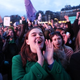 Frauen versammeln sich in der Nähe des Eiffelturms auf dem Place du Trocadero in Paris, Frankreich, am 4. März 2024, während der Übertragung der Einberufung beider Häuser des Parlaments zur Verankerung des Rechts auf Abtreibung in der Verfassung des Landes. 