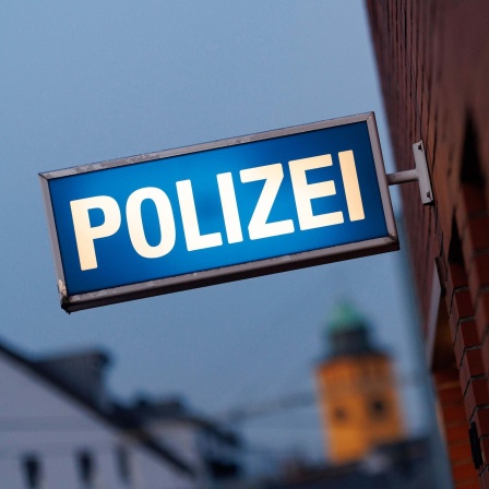 Symbolbild: An einer Gebäudewand hängt ein beleuchtetes Schild mit der Aufschrift "Polizei".