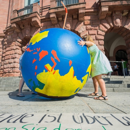 Teilnehmer der Aktion zum Erdüberlastungstag in Mainz stellen eine riesige Weltkugel auf dem Gutenbergplatz auf. Mit der Aktion will der &#034;BUND&#034; (Bund für Umwelt und Naturschutz Deutschland) auf den weltweiten Erdüberlastungstag aufmerksam machen. Der Erdüberlastungstag ist der Tag, an dem die weltweit zur Verfügung stehenden Ressourcen verbraucht sind.