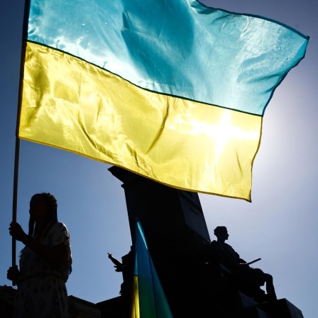 Nationalflaggen der Ukraine in gelb und blau werden bei einer Demonstration geschwenkt, 2023.