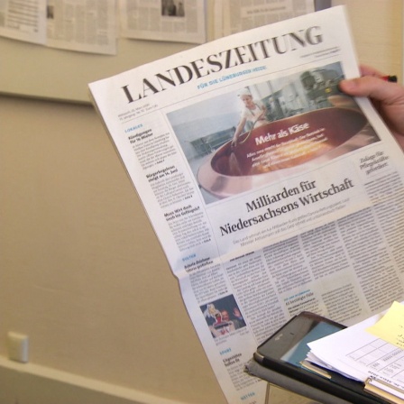 Ein Mann hält eine Ausgabe der Lüneburger Landeszeitung in der Hand.