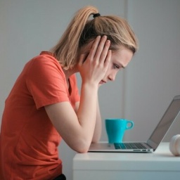 Junge Unruhige Frau, Die Laptop Zu Hause Benutzt