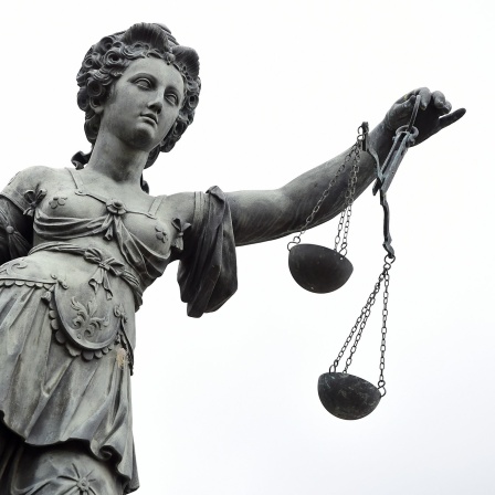 Eine Bronzestatue der römischen Göttin Justitia mit Waage und Richtschwert in der Hand