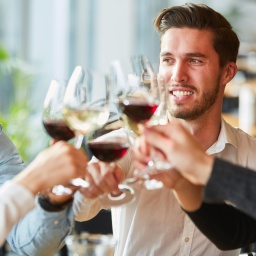 Freunde stoßen an mit Wein im Restaurant