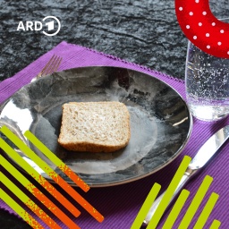 Ein Teller mit einem trockenen Stück Toast und ein Glas Wasser stehen auf einem Tisch.