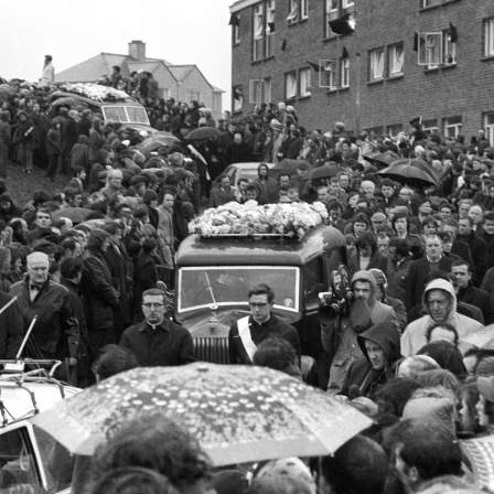 Eine Menschenmenge begleitet die Leichenwagen während des Beerdigungzuges Anfang Februar 1972 in Londonderry, Irland