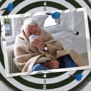 Eine Bildmontage zeigt eine Dartscheibe. Darauf ist eine Postkarte zu sehen. Sie zeigt einen älteren Mann, der mit einer Tasse in der Hand und in eine Decke gehüllt an der Heizung sitzt.