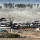 Ein Tsunami rollt auf Häuser in Japan zu.