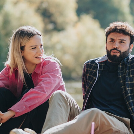 Drei Freunde sitzen in einem Park und unterhalten sich