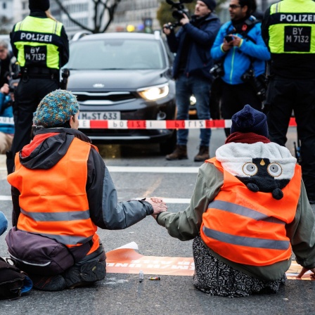 Aktivisten der Klimaschutz-Initiative "Letzte Generation" haben sich mit ihren Händen auf die Straße geklebt