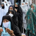 Betende Frauen tragen Mundschutz und Handschuhe beim Fest des Fastenbrechens in Tehran 2020.