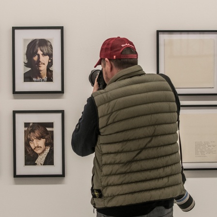 Im Bild ein Fotograf der Portraitfotos der Beatels fotografiert daneben das weiße Album. British Pop Art