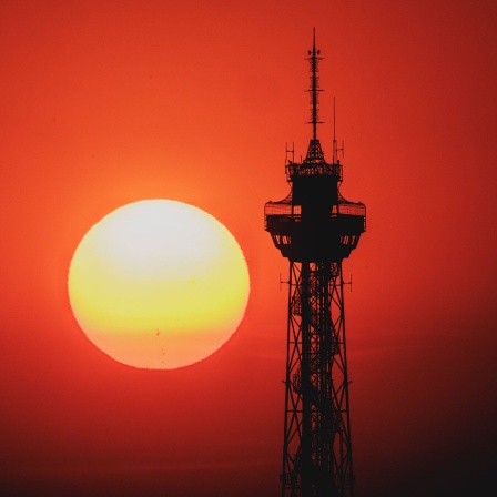 Der Sonnenaufgang zeichnet sich ab hinter dem Funkturm in Berlin.