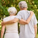 Glückliches Paar Senioren geht spazieren Arm in Arm in der Natur im Sommer