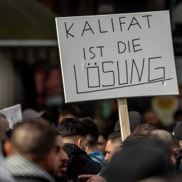 Ein Demonstrant hält ein Plakat mit der Aufschrift: &#034;Kalifat ist die Lösung&#034;
