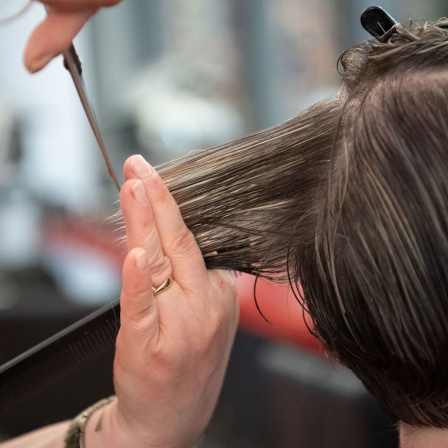 Eine Friseurin schneidet einer Kundin die Haare in einem Friseursalon.