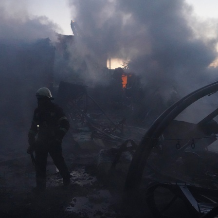 Feuerwehrleute versuchen, das Feuer nach einem Treffer durch russischen Granatenbeschuss in Charkow, Ukraine, zu löschen.