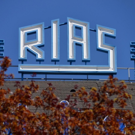 Der RIAS-Schriftzug auf dem Funkhaus am Hans-Rosenthal-Platz in Berlin vor strahlend blauem Himmel