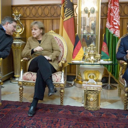 Bundeskanzlerin Angela Merkel am 06.04.2009 in Masar-i-Sharif in Afghanistan während eines Treffens mit dem Provinzgouverneur von Balkh, Mohammad Atta und Bundesverteidigungsminister Franz Josef Jung.