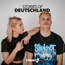 Eine Mann und eine Frau stehen vor einer weißen Wand, die Frau lehnt sich aufrecht an die Schulter des Mannes, dazu das Logo von Stories of Deutschland.
