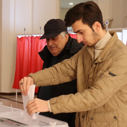 Zwei Männer geben ihre Stimmen bei der vorgezogenen Präsidentenwahl in der aserbaidschanischen Hauptstadt ab.