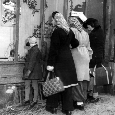 Passanten betrachten 1945 das weihnachtlich dekorierte Schaufenster eines Geschäftes in Frankfurt am Main. (Archivbild)