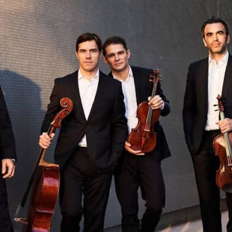 Das Quatuor Modigliani mit Instrumenten an eine Mauer angelehnt