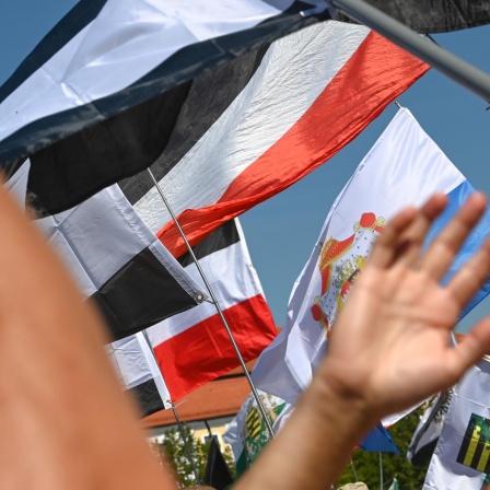 Reichsflaggen werden auf dem Magdeburger Domplatz zur Reichsbürgerkundgebung hochgehalten