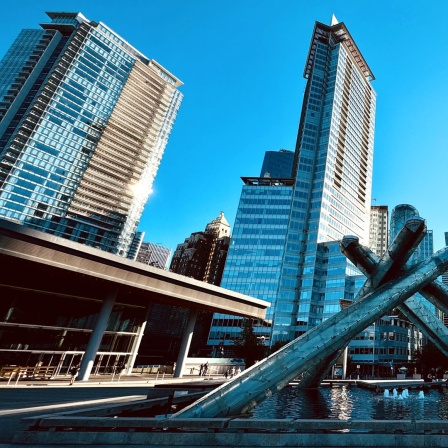 Die Skyline von Vancouver mit hohen Gebäuden und einem erloschenen Olympischen Feuer der 2010 ausgerichteten Spiele
