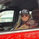 "Basil Brave Heart" sitzt in einem roten SUV Truck am Steuer.