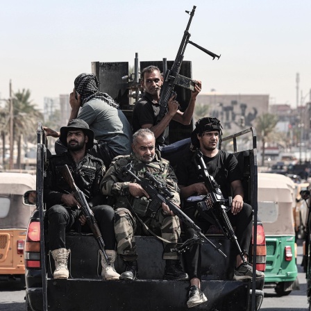 Bewaffnete Mitglieder von Saraya al-Salam («Friedenskompanie»), dem militärischen Flügel des schiitischen Geistlichen Al-Sadr, fahren in einem Fahrzeug während Zusammenstößen mit irakischen Sicherheitskräften in der Grünen Zone. 