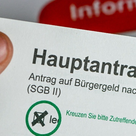 Antrag auf Bürgergeld in der Hand eines Mannes. Erhöhung soll rückgängi gemacht werden.