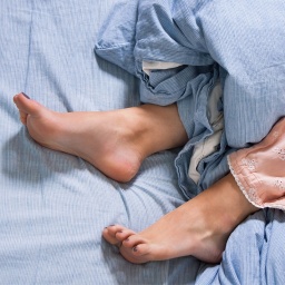Frauenbeine im Bett 