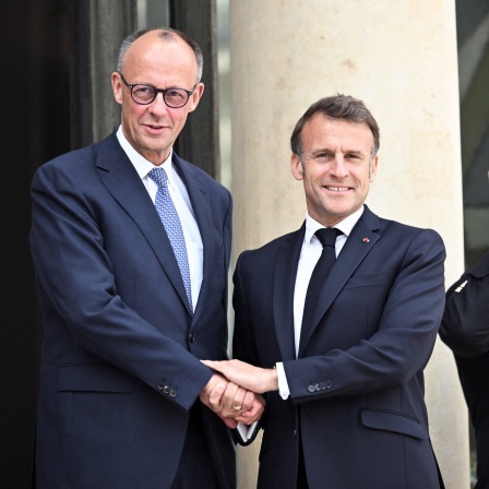 Bundeskanzler Friedrich Merz wird bei seinem Antrittsbesuch in Frankreich von Macron mit beidhändigem Handschlag begrüßt
