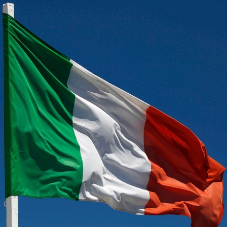 Die italienische Flagge weht gegen einen hellblauen Himmel