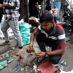 Ein Mann sucht nach Elktroschrott in der Nähe von Neu Delhi, Indien 