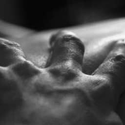 Eine Hand greift in die Haut eines anderen Menschen.