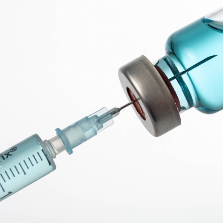 Spritze wird mit Impfstoff aufgezogen: Wissenschaftler weltweit arbeiten an neuartigen Impfstoffen und Medikamenten, die gegen ganze Virusfamilien wirken. Beispielsweise nicht nur gegen SARS-CoV-2, sondern gegen alle Corona-Viren.