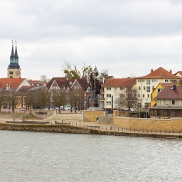 Blick auf eine Uferpromenade am Elbufer in Schönebeck, unter anderem ist die Skulptur "Salzblume" zu sehen.