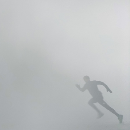 Eine Person rennt bei Nebel. 