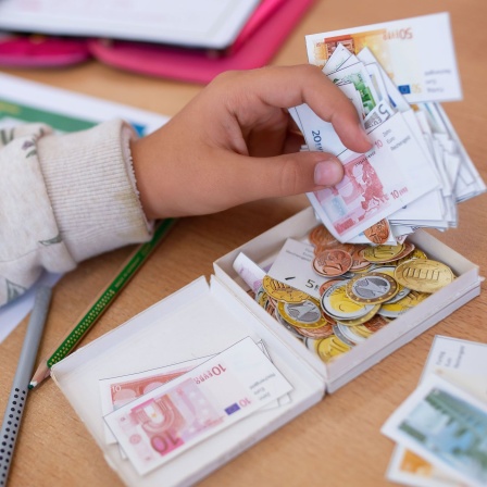 Eine Schülerin einer 2. Klasse rechnet im Klassenzimmer einer Grundschule mit Spielgeld (Bild: picture alliance/dpa/Sven Hoppe)